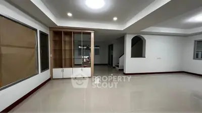 Spacious modern living room with built-in shelving and glossy tiled floors.