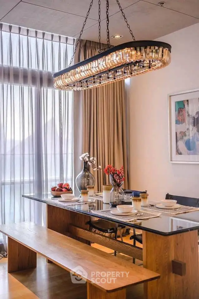 Elegant dining area with modern chandelier and large windows, perfect for entertaining in style.