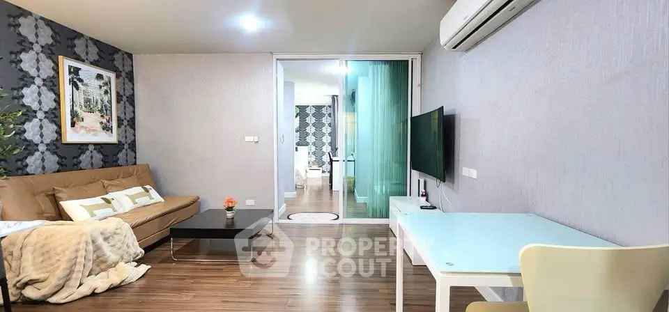 Modern living room with stylish decor and open layout, featuring a cozy sofa and sleek TV setup.
