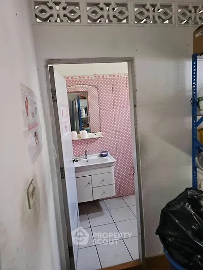Charming bathroom with pink polka dot wallpaper and white vanity unit, perfect for a cozy home.