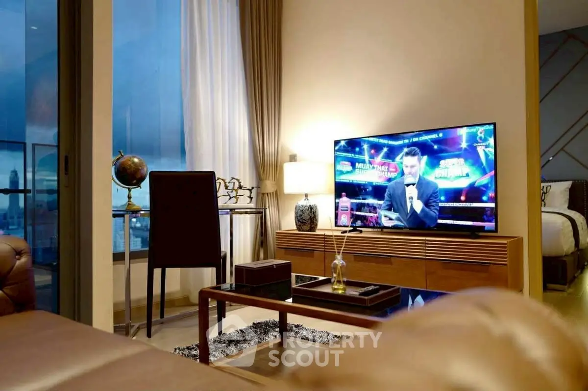 Modern living room with stylish decor and large TV, perfect for entertainment.
