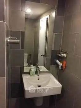 Modern bathroom with sleek sink and large mirror in stylish apartment.