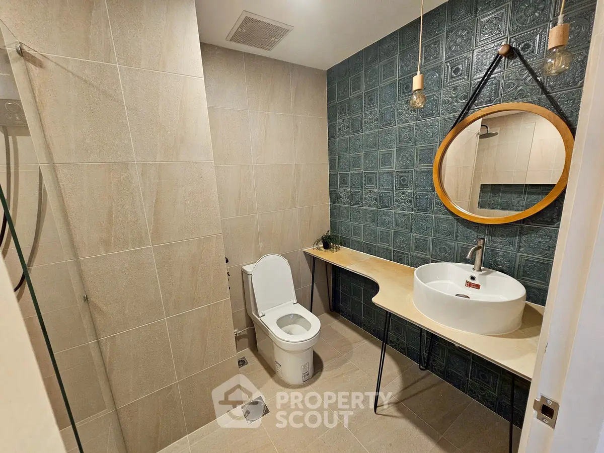 Modern bathroom with stylish tiles and round mirror