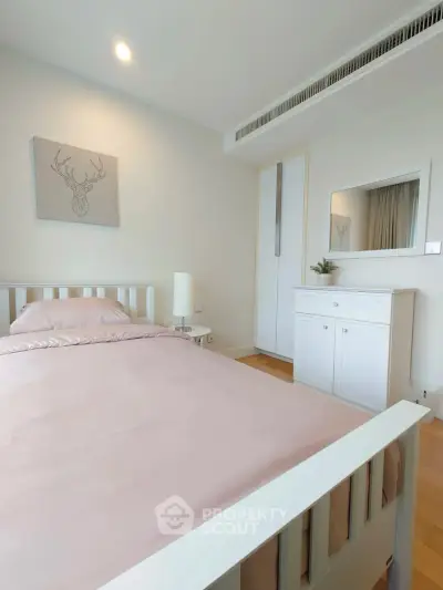 Cozy bedroom with minimalist decor and soft lighting, perfect for relaxation.