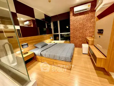 Modern bedroom with wooden flooring and brick accent wall, featuring a cozy bed and stylish decor.