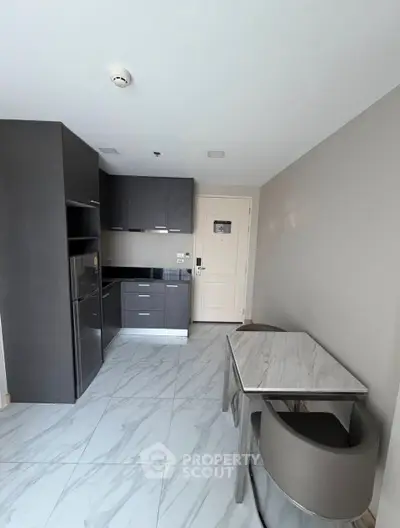 Modern kitchen with sleek cabinets and dining area in stylish apartment