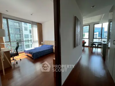 Spacious modern apartment with wooden flooring and large windows offering city views.