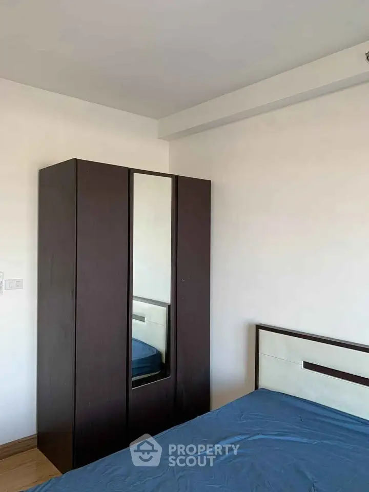 Cozy bedroom with modern wardrobe and stylish bed frame, perfect for urban living.