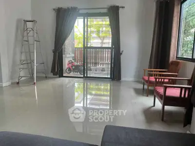 Spacious living room with large windows and modern furniture, offering a bright and airy atmosphere.