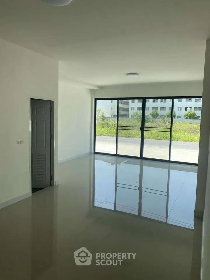 Spacious modern living room with large windows and glossy floors