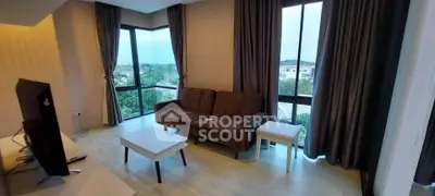 Spacious living room with large windows and modern furniture, offering a scenic view.