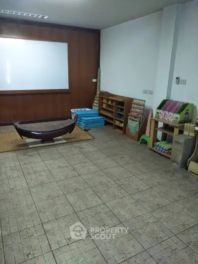 Spacious room with tiled floor, wooden shelving, and a whiteboard, ideal for educational or office use.