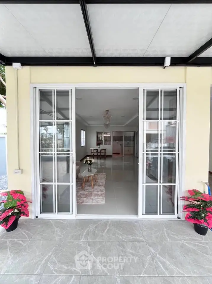 Spacious modern living room with elegant decor and large glass doors opening to a stylish patio.