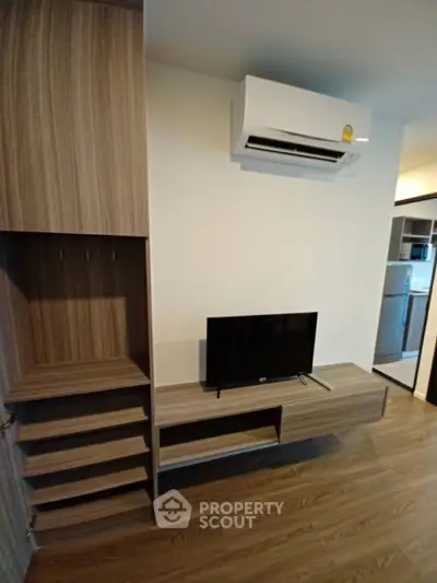 Modern living room with sleek wooden furniture and air conditioning unit, perfect for comfortable living.