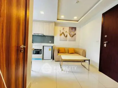 Modern living room with cozy sofa, stylish decor, and compact kitchen area in a chic apartment.