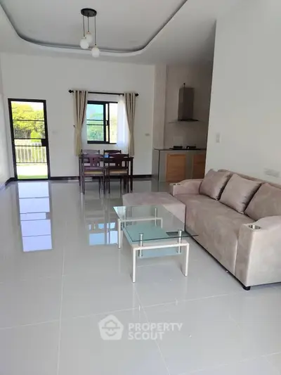 Spacious modern living room with sleek furniture and open kitchen layout, perfect for contemporary living.