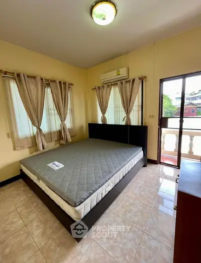 Spacious bedroom with large windows and balcony access in modern apartment