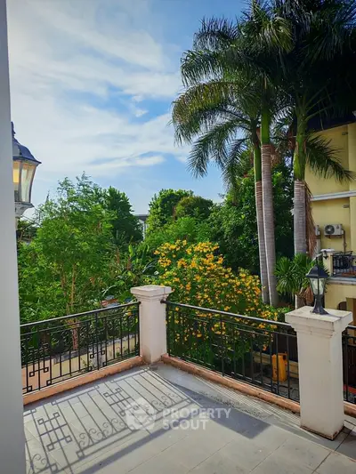 Charming balcony with lush greenery and palm trees, perfect for relaxation and enjoying nature.