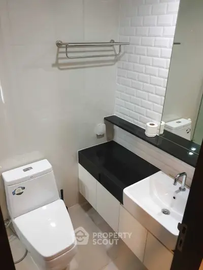 Modern bathroom with sleek black countertop and white fixtures