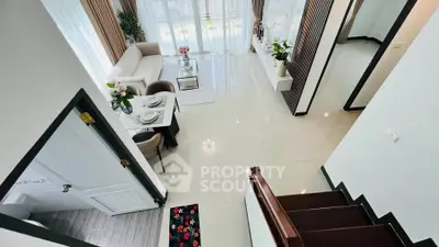 Spacious modern living room with elegant decor and large windows offering natural light.