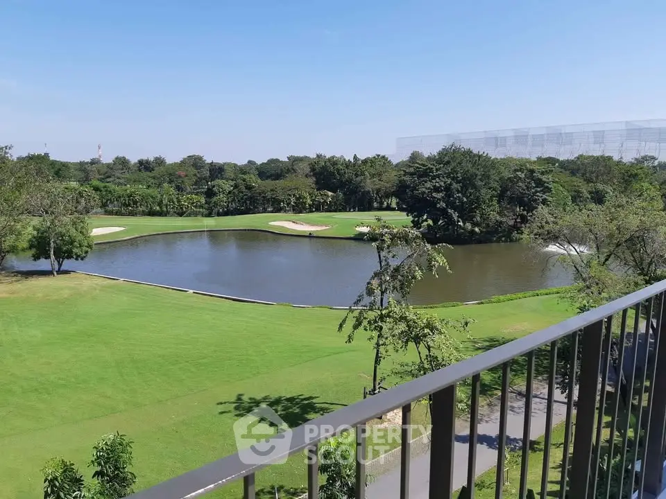 Stunning golf course view from balcony with lush greenery and serene water feature.