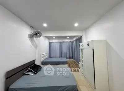 Spacious bedroom with two beds and modern furnishings, ideal for comfortable living.