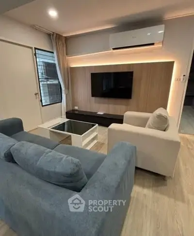 Modern living room with stylish furniture and wall-mounted TV