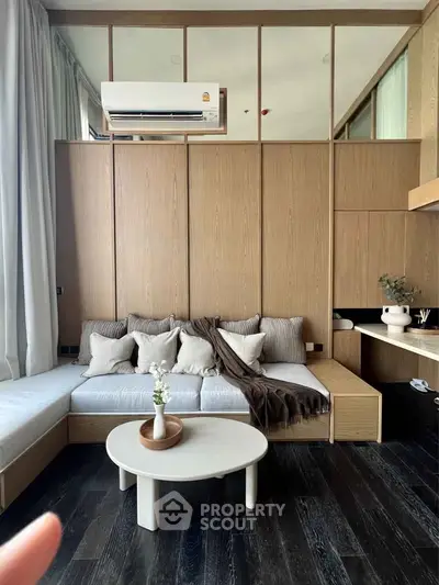 Modern living room with stylish furniture and air conditioning, featuring a cozy seating area and elegant decor.