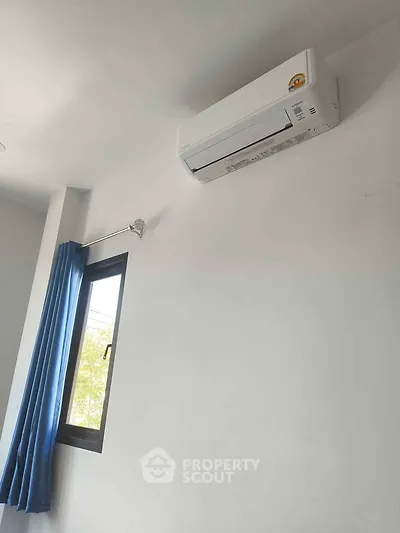 Modern room with air conditioning and window with blue curtains.