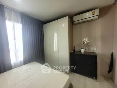 Cozy bedroom with modern wardrobe and air conditioning in a stylish apartment.