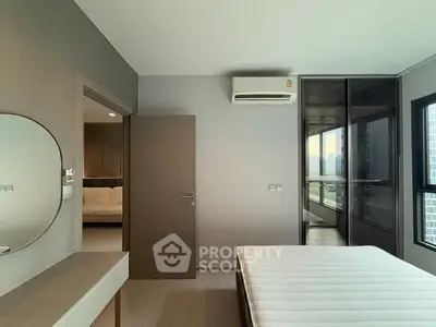 Modern bedroom with sleek design and large windows offering natural light.