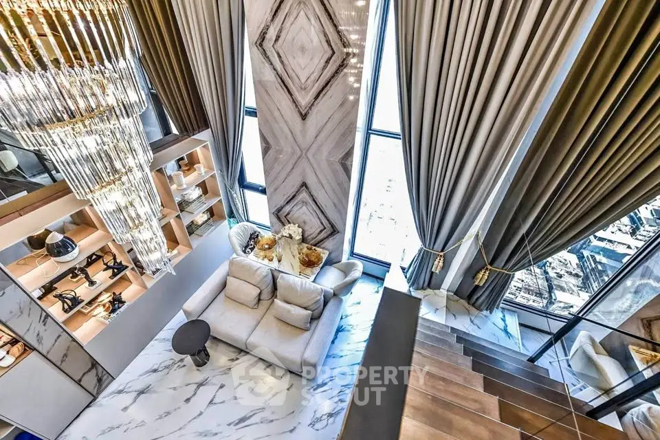 Luxurious modern living room with high ceilings, elegant chandelier, and floor-to-ceiling windows.