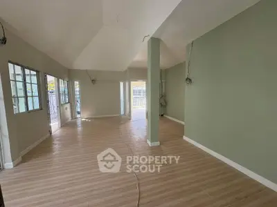 Spacious unfurnished room with large windows and wooden flooring