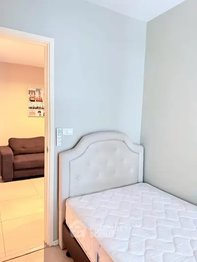 Cozy bedroom with elegant headboard and glimpse of living room, perfect for modern living.