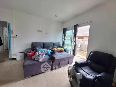 Cozy living room with plush sofa and large window offering natural light.