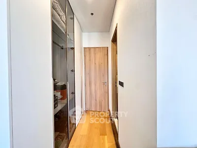 Modern hallway with wooden flooring and sleek storage cabinets in a contemporary apartment.