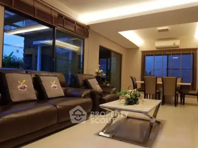 Luxurious living room with elegant leather sofas and modern dining area, perfect for entertaining.