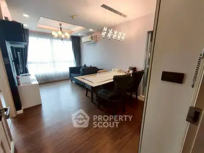 Spacious living room with elegant dining area and modern lighting in a cozy apartment.