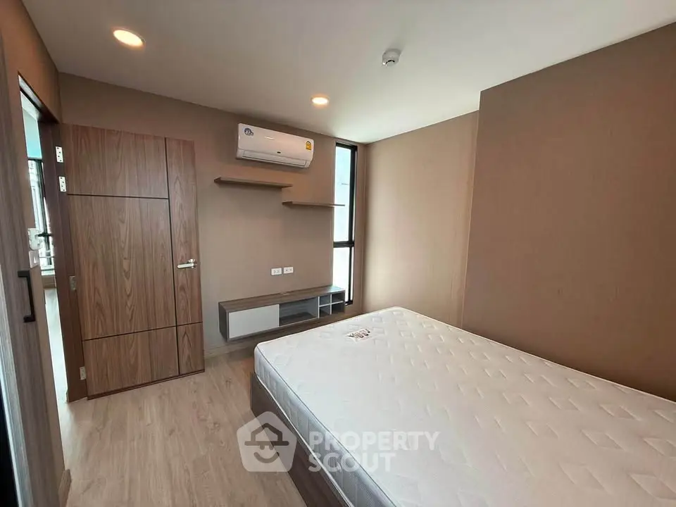 Modern bedroom with minimalist design, featuring a large bed and built-in air conditioning.