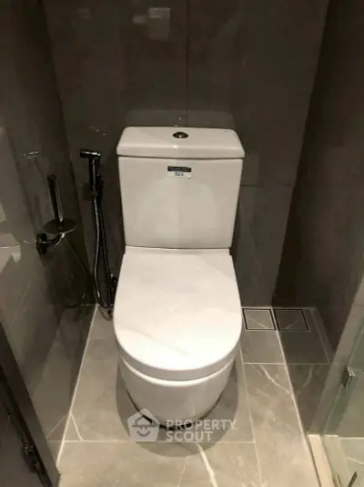 Modern bathroom with sleek toilet and elegant tile flooring, perfect for contemporary living spaces.