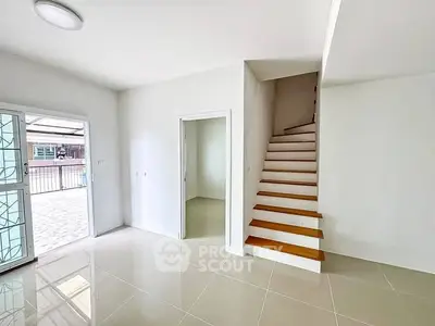 Bright interior with modern staircase and tiled flooring in a spacious home.