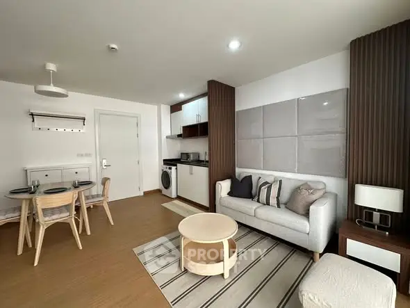 Modern living room with open kitchen, stylish decor, and cozy dining area in a contemporary apartment.