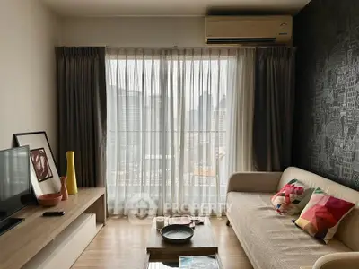 Modern living room with city view, featuring stylish decor and natural light through large windows.