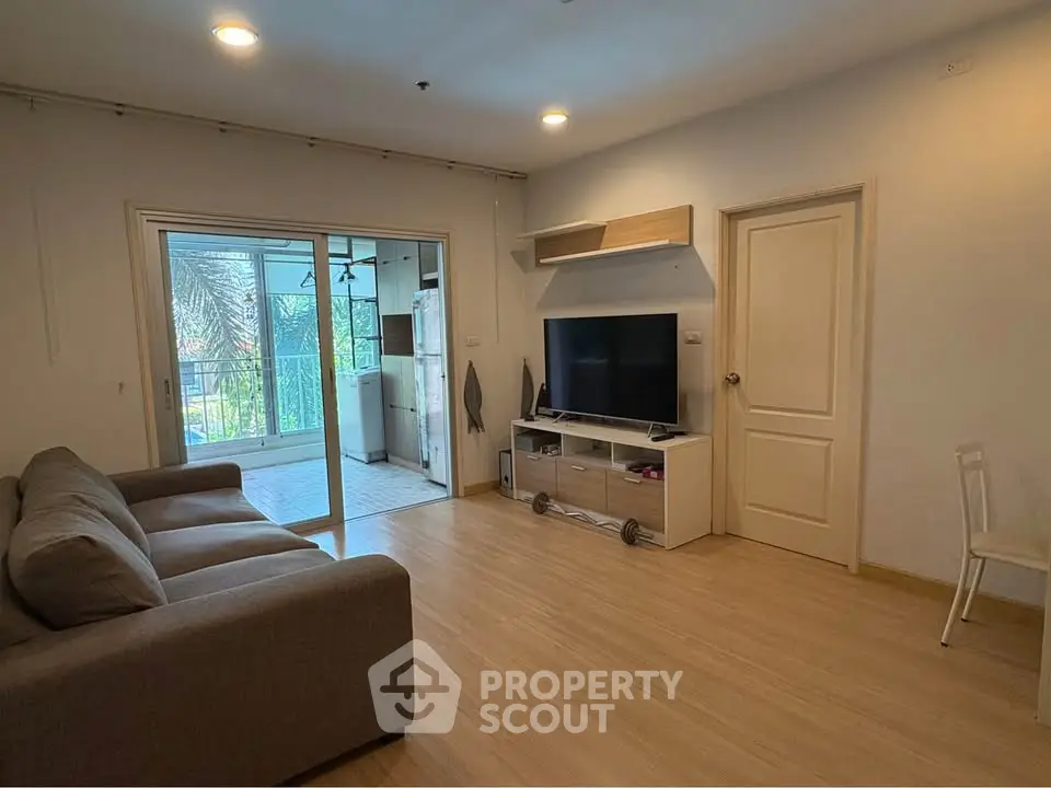 Spacious living room with modern decor and balcony access in a stylish apartment.