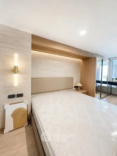 Modern bedroom with stylish lighting and mirrored wardrobe in a contemporary apartment.