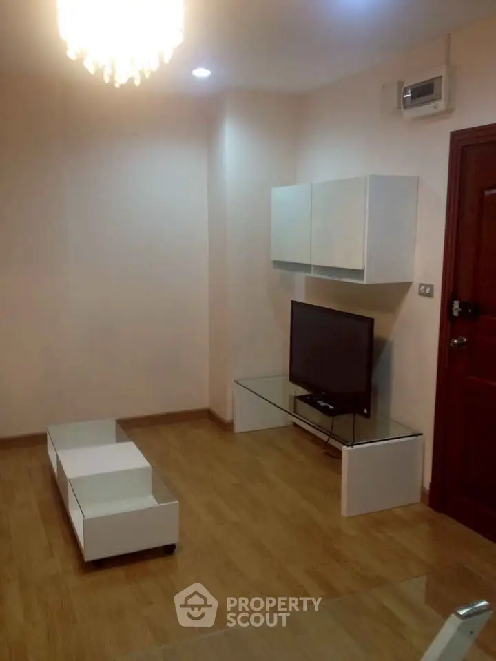 Modern living room with sleek furniture and mounted TV in a cozy apartment.