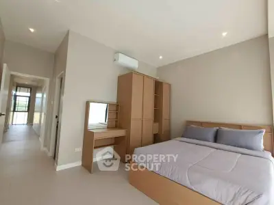 Spacious modern bedroom with natural light and sleek furniture