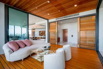 Luxurious modern living room with wooden ceiling and sliding doors, featuring elegant furniture and open layout.