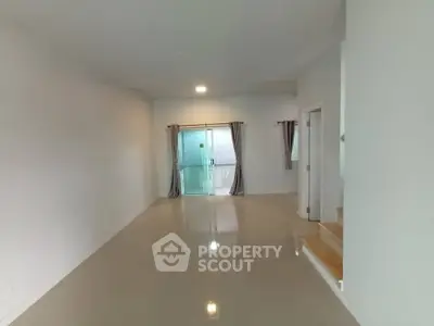 Spacious empty room with glossy tiled floor and sliding glass doors