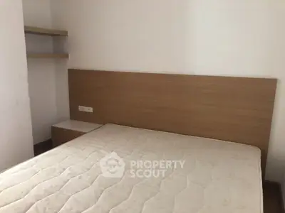 Cozy bedroom with minimalist design and built-in shelves, perfect for modern living.